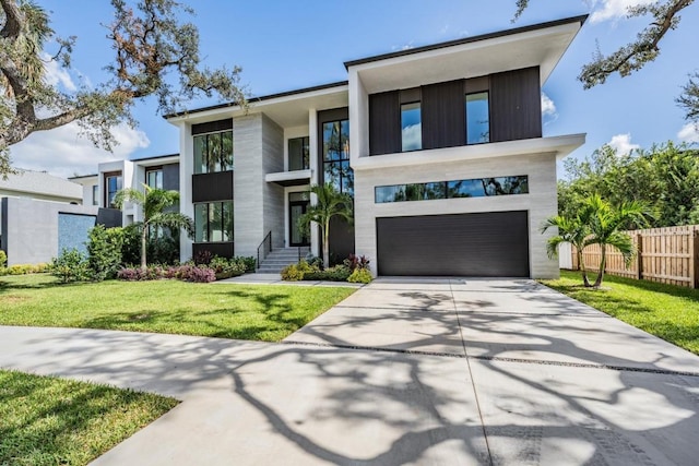 modern home featuring a front yard and a garage