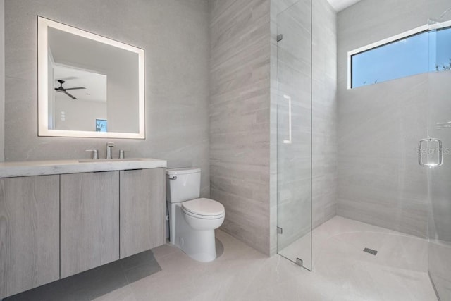 bathroom featuring tile patterned floors, toilet, a shower with shower door, vanity, and ceiling fan