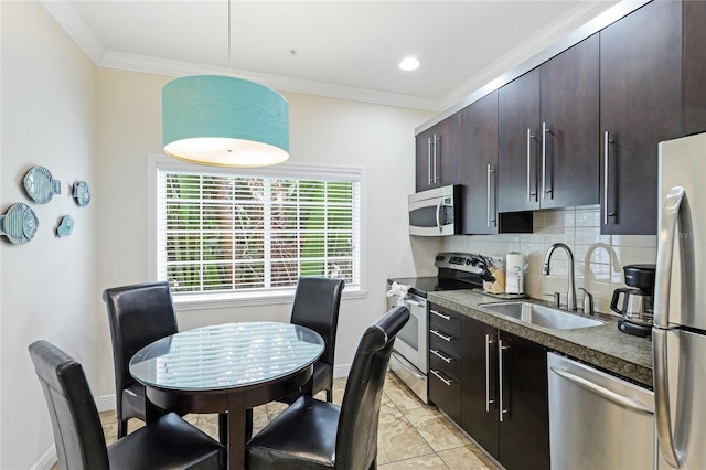 kitchen featuring backsplash, crown molding, stainless steel appliances, sink, and light tile patterned flooring