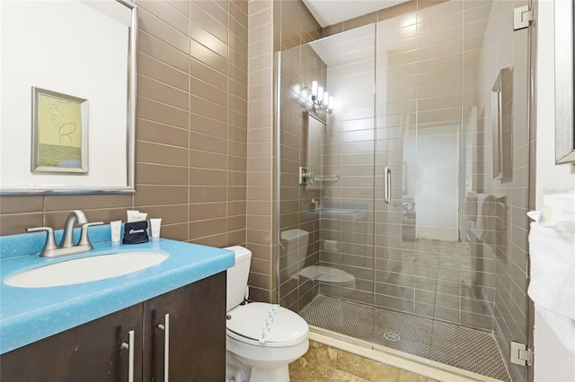 bathroom featuring tile walls, toilet, an enclosed shower, and vanity