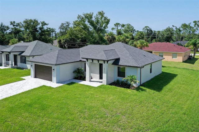 view of front of house with a shingled roof, decorative driveway, a front lawn, and an attached garage