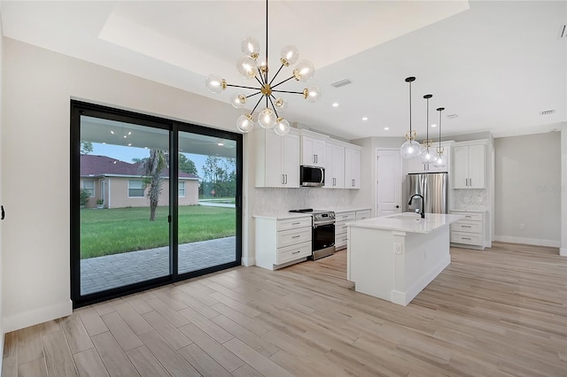 kitchen with stainless steel appliances, light countertops, white cabinetry, and decorative backsplash