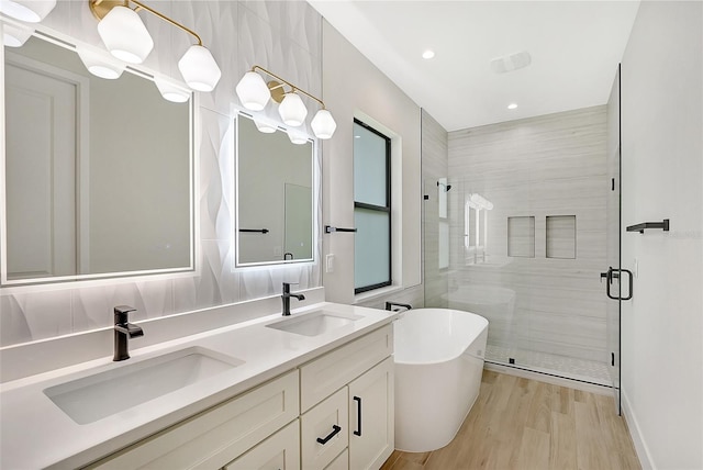 full bathroom with a freestanding tub, a shower stall, and a sink