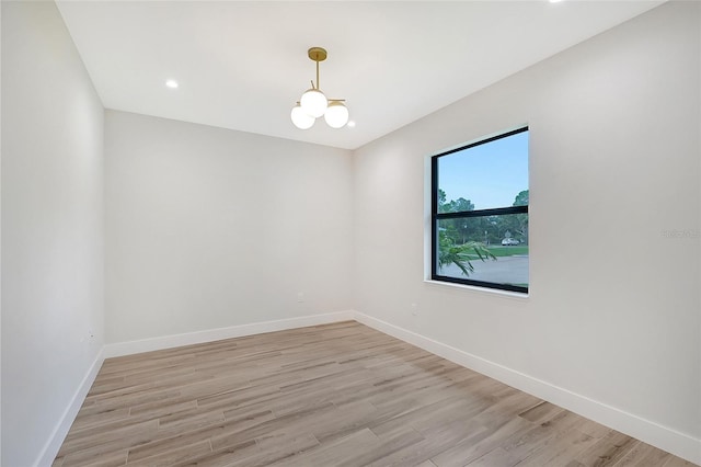 unfurnished room with a chandelier, light wood-type flooring, baseboards, and recessed lighting