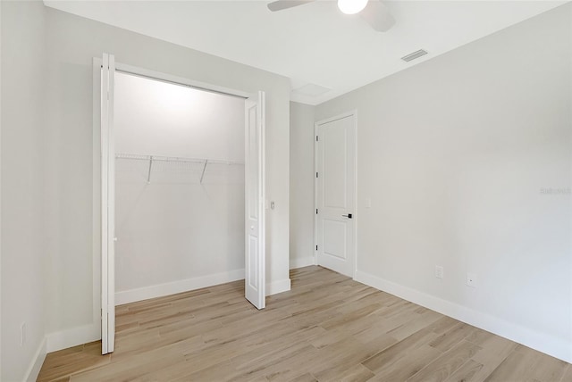 unfurnished bedroom featuring a closet, wood finished floors, visible vents, and baseboards