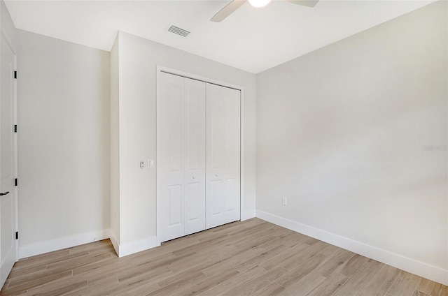 unfurnished bedroom with a closet, visible vents, light wood-style flooring, and baseboards