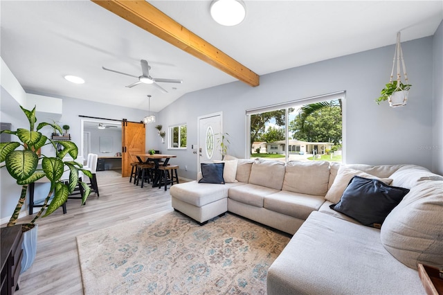 living room with a barn door, ceiling fan, light wood-type flooring, and vaulted ceiling with beams