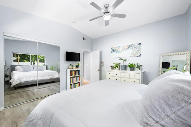 bedroom featuring light wood-type flooring, a closet, ceiling fan, and vaulted ceiling