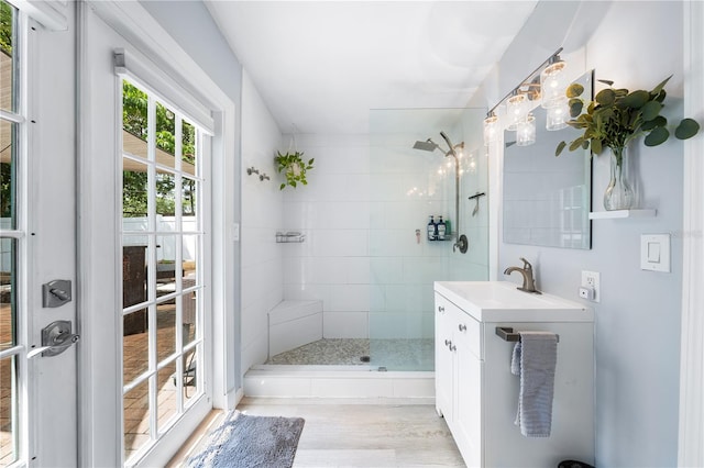 bathroom with vanity, wood-type flooring, and tiled shower