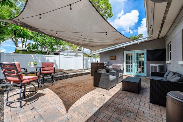 view of patio / terrace with an outdoor living space, central air condition unit, and french doors