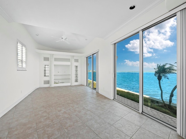 unfurnished living room featuring a wealth of natural light, built in features, and a water view