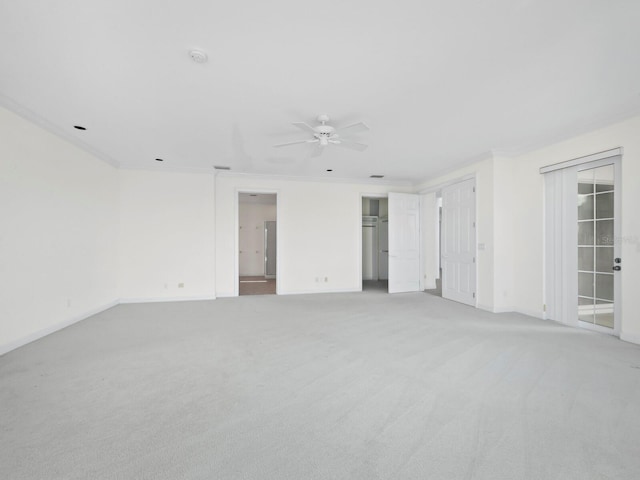 carpeted spare room with ceiling fan and ornamental molding