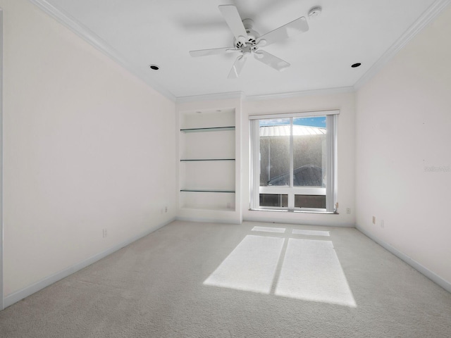 carpeted empty room with ceiling fan and crown molding