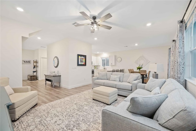 living room with ceiling fan and light hardwood / wood-style flooring