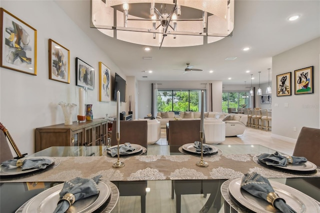 tiled dining room featuring ceiling fan with notable chandelier