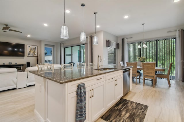 kitchen featuring white cabinetry, sink, an island with sink, and ceiling fan