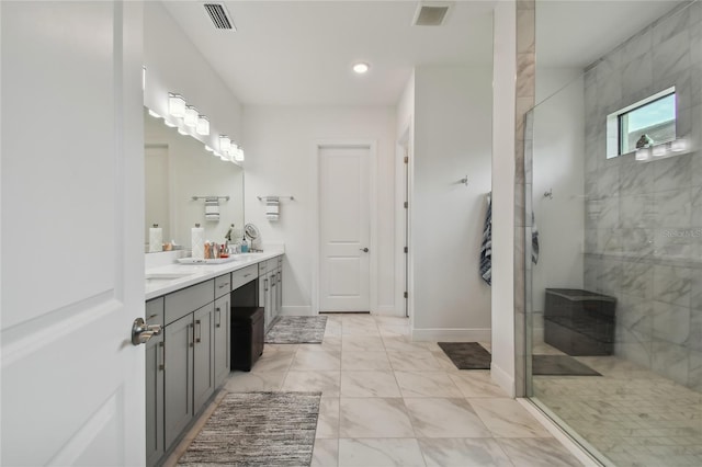 bathroom featuring tiled shower and vanity