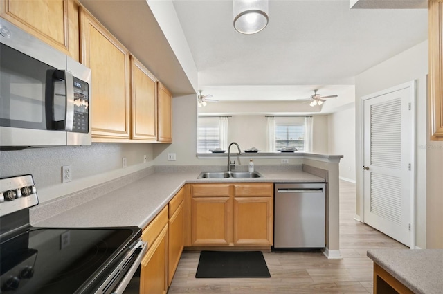 kitchen featuring appliances with stainless steel finishes, sink, ceiling fan, kitchen peninsula, and light brown cabinets