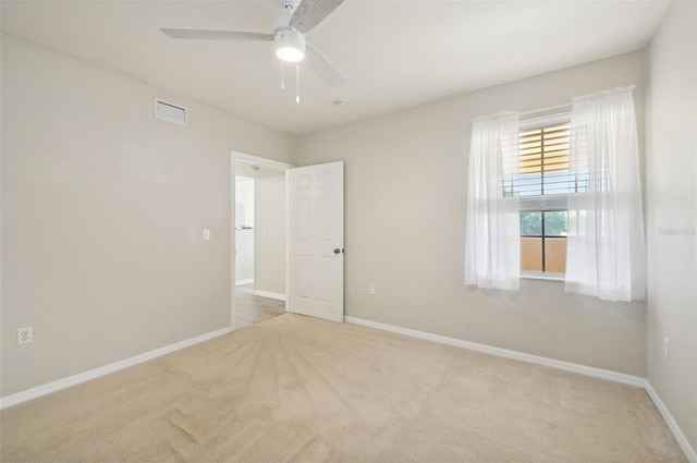 carpeted spare room featuring ceiling fan