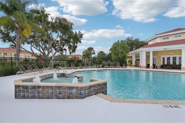 view of swimming pool featuring a patio area and a hot tub