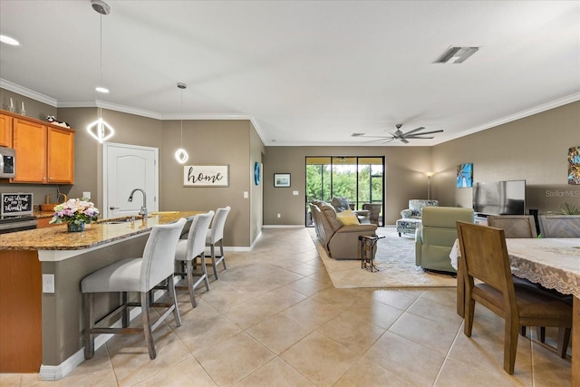 tiled living room with ceiling fan, crown molding, and sink