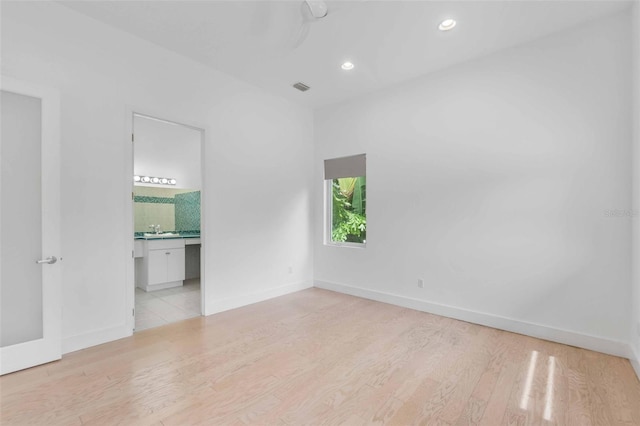 unfurnished room featuring sink and light hardwood / wood-style floors