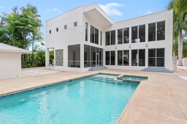 rear view of house with a patio area and a pool with hot tub