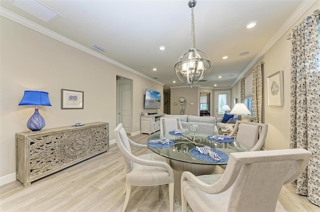 dining room with crown molding, an inviting chandelier, and light wood-type flooring