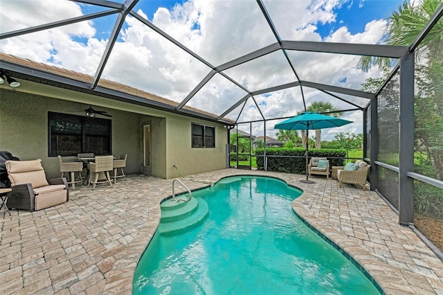 view of swimming pool with outdoor lounge area, ceiling fan, a lanai, and a patio