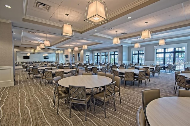 carpeted dining room featuring ornamental molding and a raised ceiling