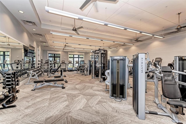 exercise room featuring light carpet and ceiling fan