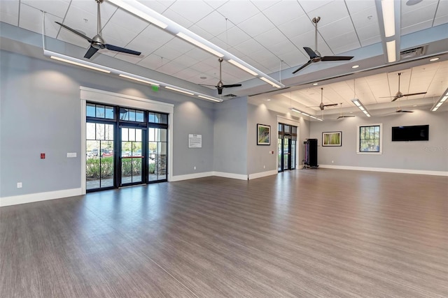 spare room featuring a towering ceiling, hardwood / wood-style floors, and ceiling fan