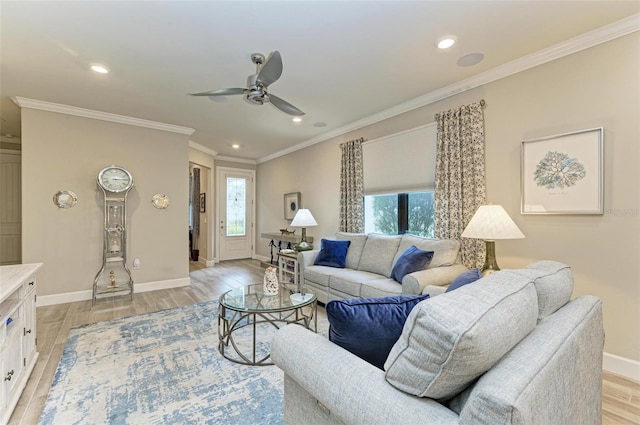 living room featuring ceiling fan, ornamental molding, plenty of natural light, and light hardwood / wood-style flooring