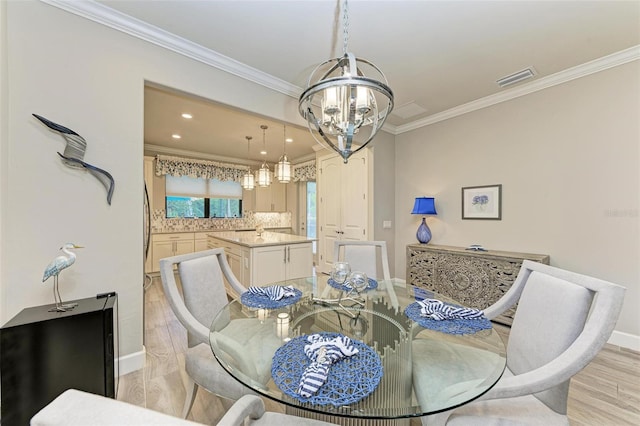 dining space with crown molding, light hardwood / wood-style floors, and a notable chandelier