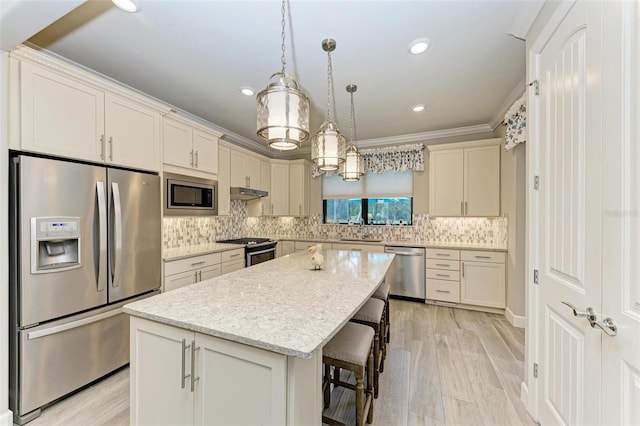 kitchen featuring decorative light fixtures, sink, a kitchen breakfast bar, a center island, and stainless steel appliances