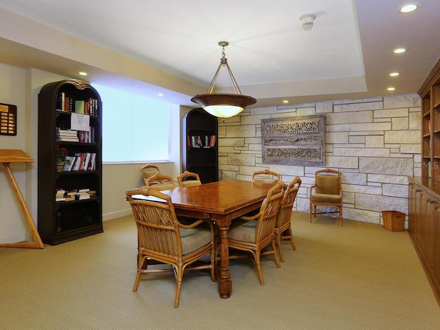 dining room with light colored carpet and a tray ceiling