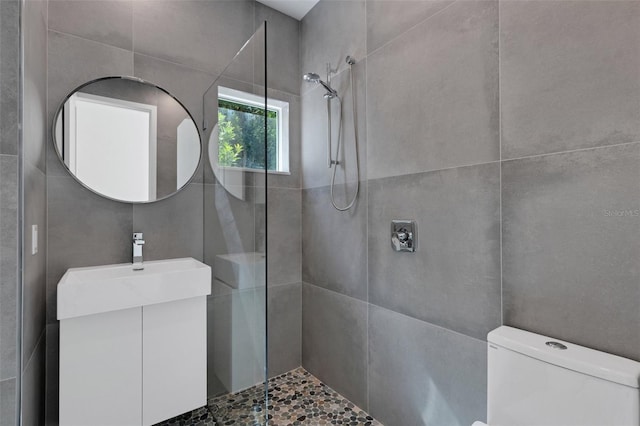 bathroom with vanity, toilet, and tiled shower