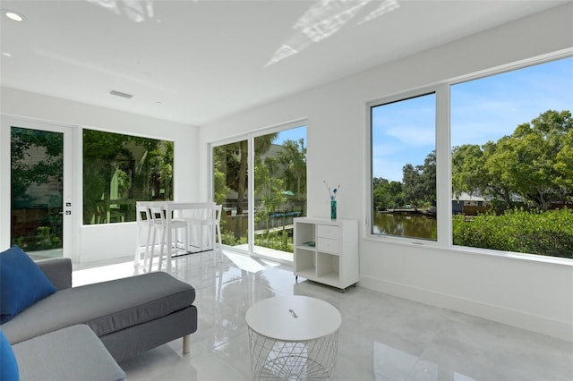 sunroom / solarium featuring a wealth of natural light and a water view