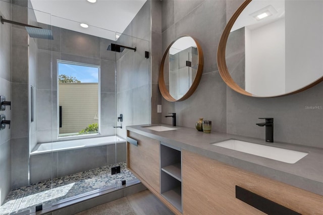 bathroom featuring tile walls, vanity, and plus walk in shower