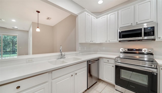 kitchen with appliances with stainless steel finishes, pendant lighting, white cabinetry, and sink