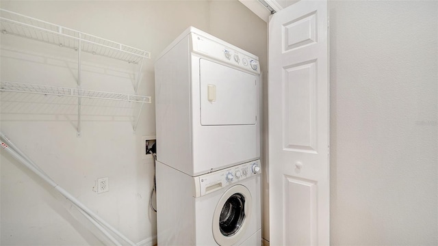 clothes washing area featuring stacked washer and clothes dryer