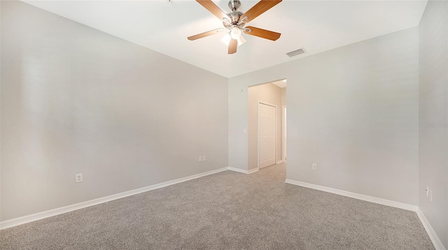 spare room featuring light carpet and ceiling fan