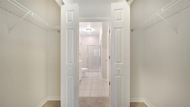 walk in closet with light tile patterned floors