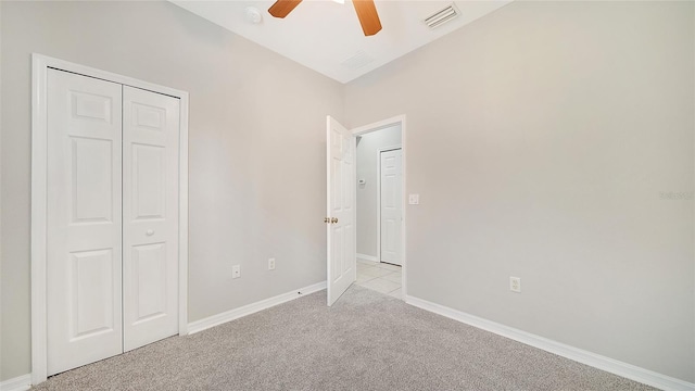 unfurnished bedroom with a closet, light colored carpet, ceiling fan, and lofted ceiling