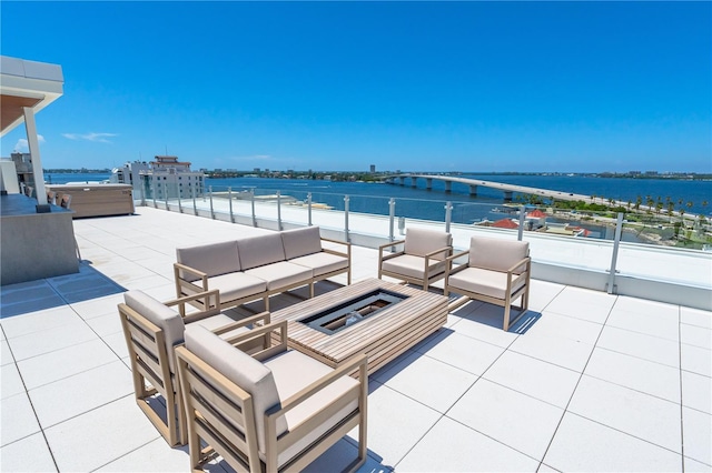 view of patio / terrace featuring an outdoor living space, a hot tub, and a water view