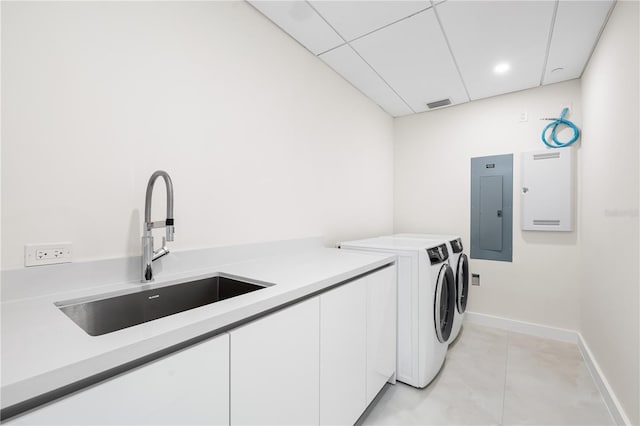 laundry room with sink, electric panel, cabinets, and washing machine and clothes dryer