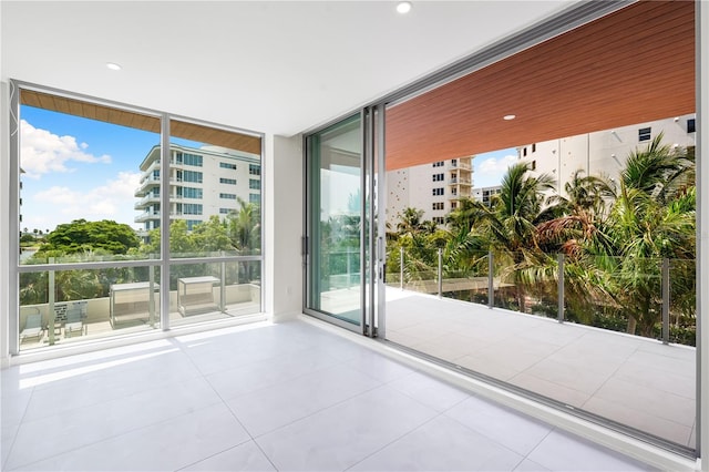 doorway featuring floor to ceiling windows and light tile patterned flooring