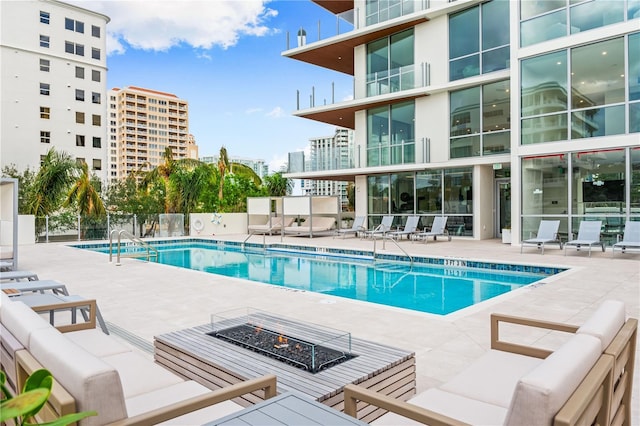 view of pool with a patio and a fire pit