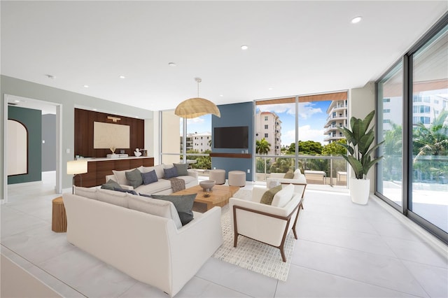 living room featuring light tile patterned floors and a wall of windows