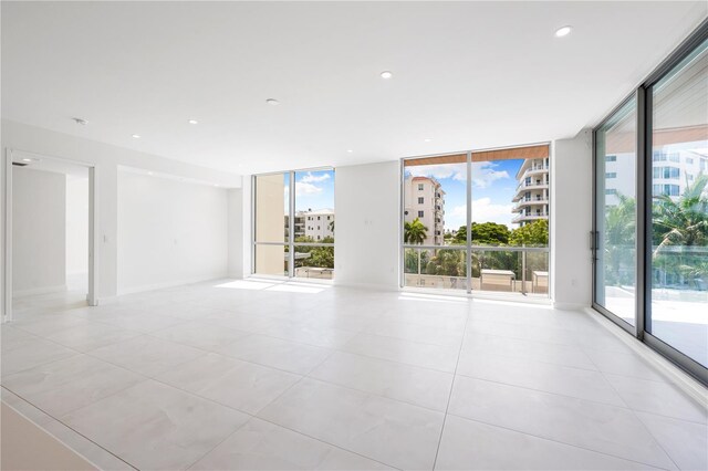 empty room featuring light tile patterned flooring and floor to ceiling windows